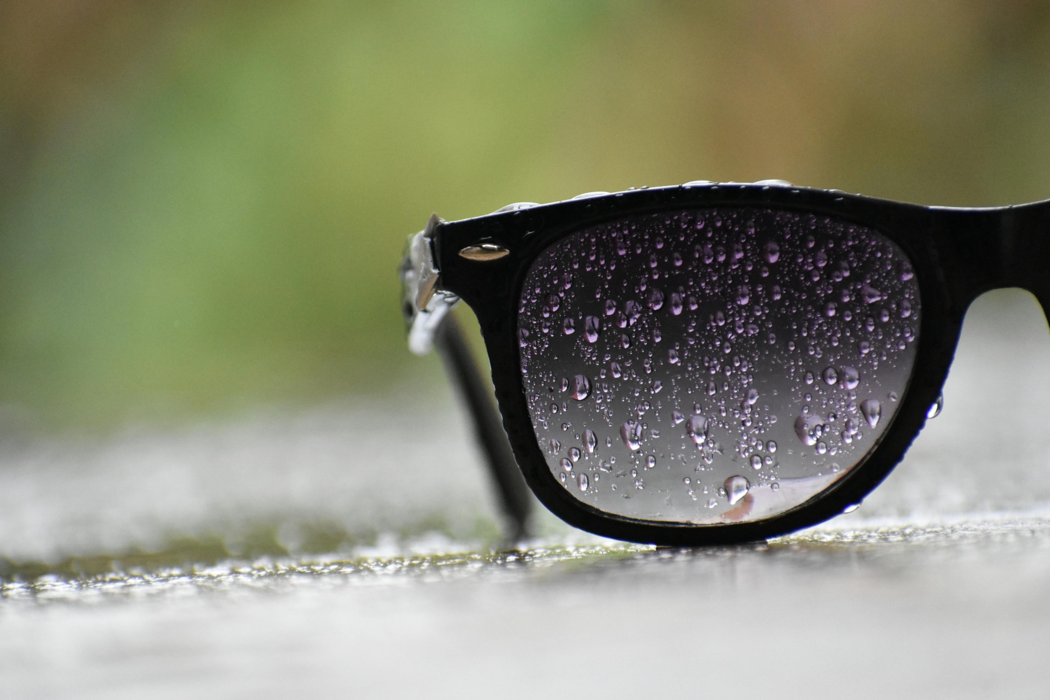 Stylish black sunglasses closeup with rain drops