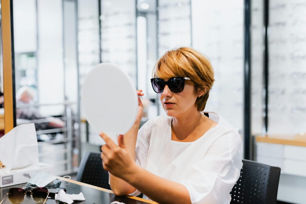 woman trying on sunglasses in optical store