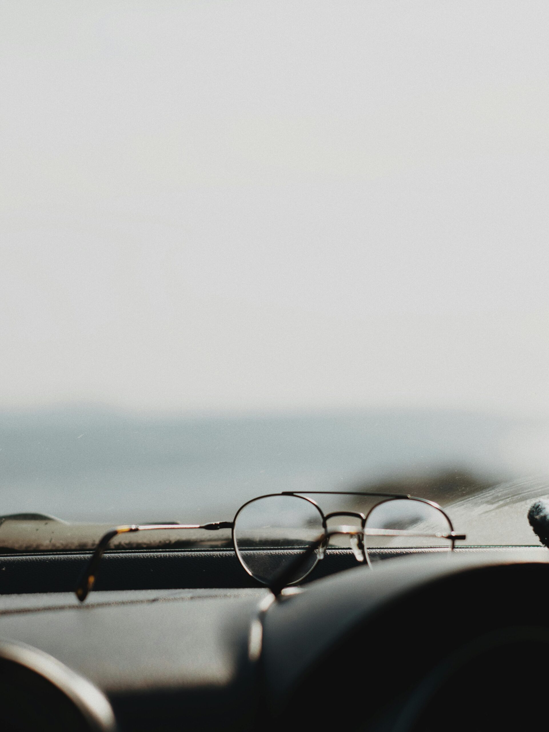Driver adjusting glasses inside a car – safe driving with prescription eyewear in the UK